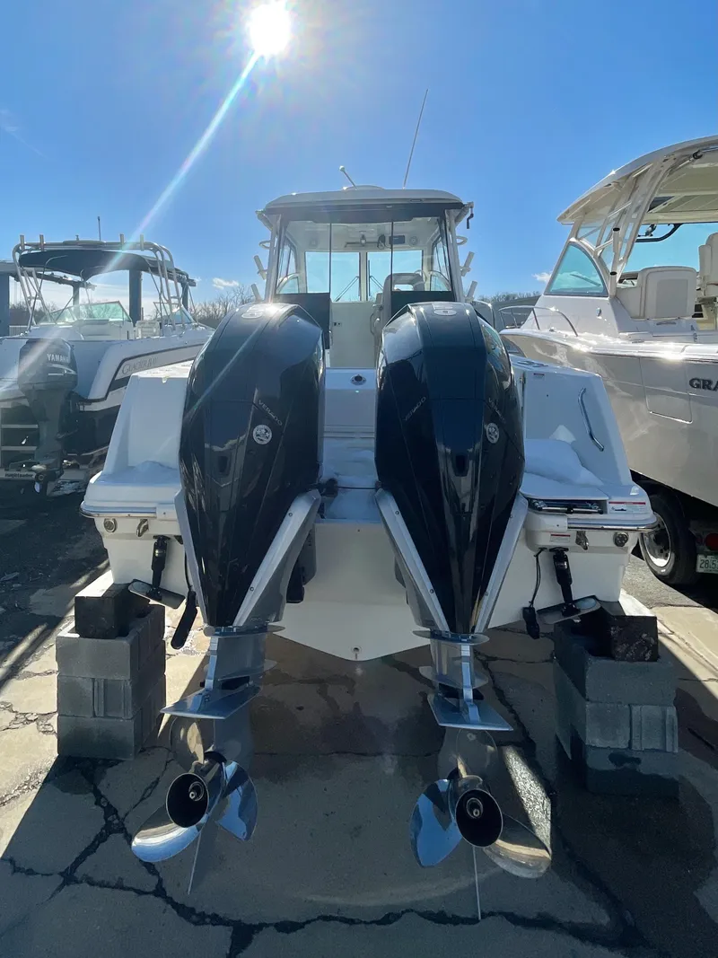 Slide: The Image of 2022 Boston Whaler 285 Conquest boat with dual engines, docked under bright sunlight. - 3