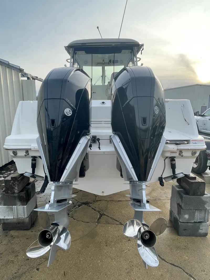 Slide: The Image of 2022 Boston Whaler 285 Conquest with dual outboard engines, docked on blocks. - 4