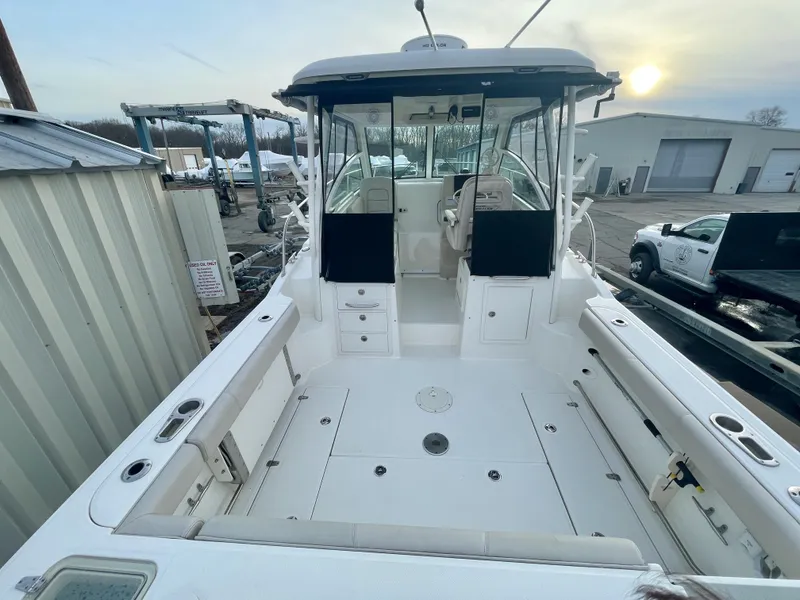 Slide: The Image of 2022 Boston Whaler 285 Conquest boat, spacious deck, docked at marina. - 6