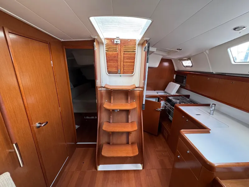 Slide: The Image of Interior of 2012 Beneteau 40 sailboat with wooden cabinetry and compact kitchen area. - 17