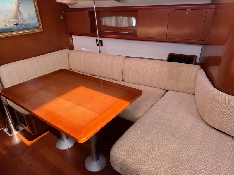 Slide: The Image of Interior of 2012 Beneteau 40 yacht with wooden table and beige seating. - 18