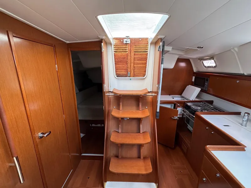 Slide: The Image of Interior of 2012 Beneteau 40 sailboat with wooden cabinetry and compact kitchen. - 2