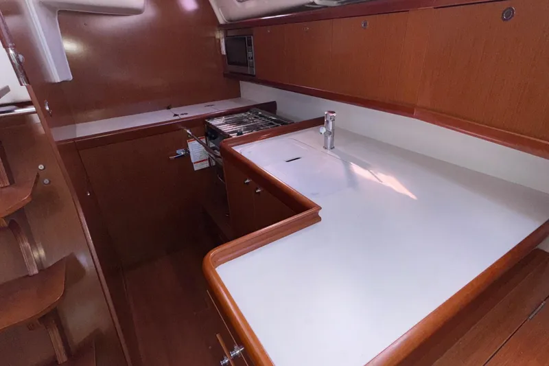 Slide: The Image of Interior view of 2012 Beneteau 40 yacht kitchen with wooden cabinetry and modern appliances. - 25