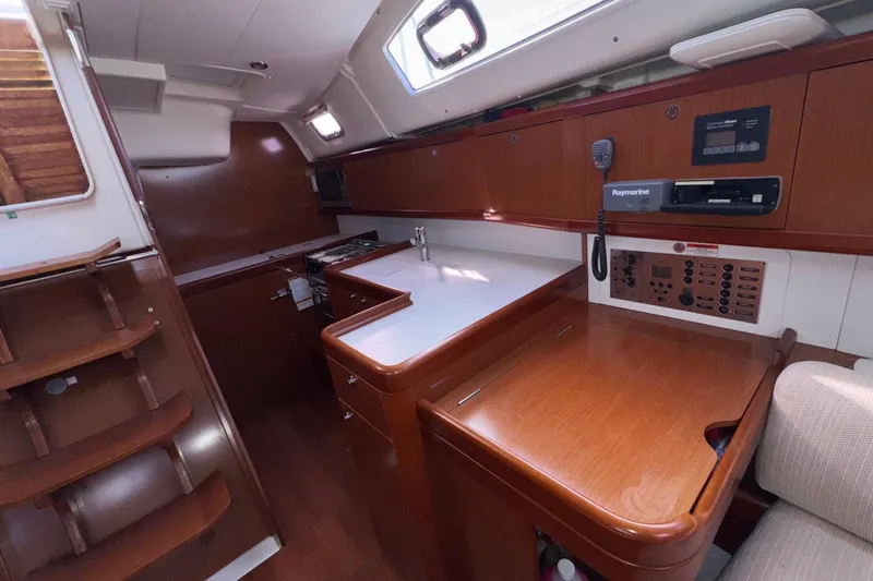 Slide: The Image of Interior of 2012 Beneteau 40 yacht, featuring a modern kitchen and navigation area. - 26