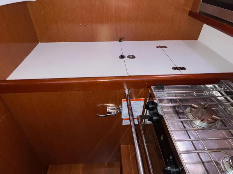 Slide: The Image of Galley kitchen in 2012 Beneteau 40 yacht with stove and wooden cabinetry. - 30