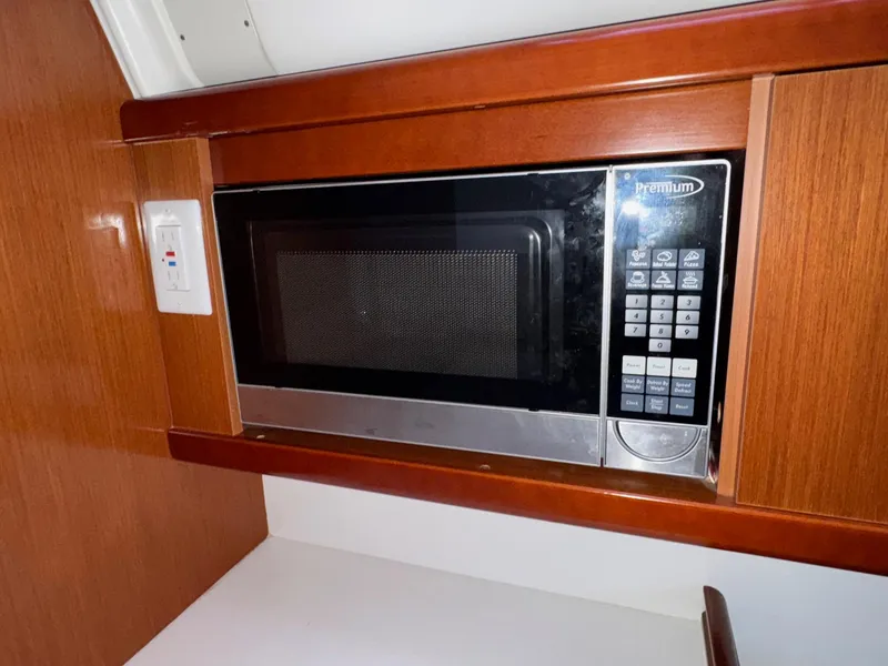 Slide: The Image of Microwave in 2012 Beneteau 40 yacht kitchen, set in wooden cabinetry. - 31