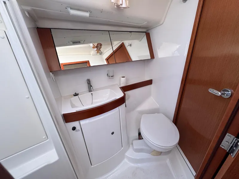 Slide: The Image of Beneteau 40 yacht bathroom, 2012 model, featuring sink, toilet, and mirrored cabinet. - 40