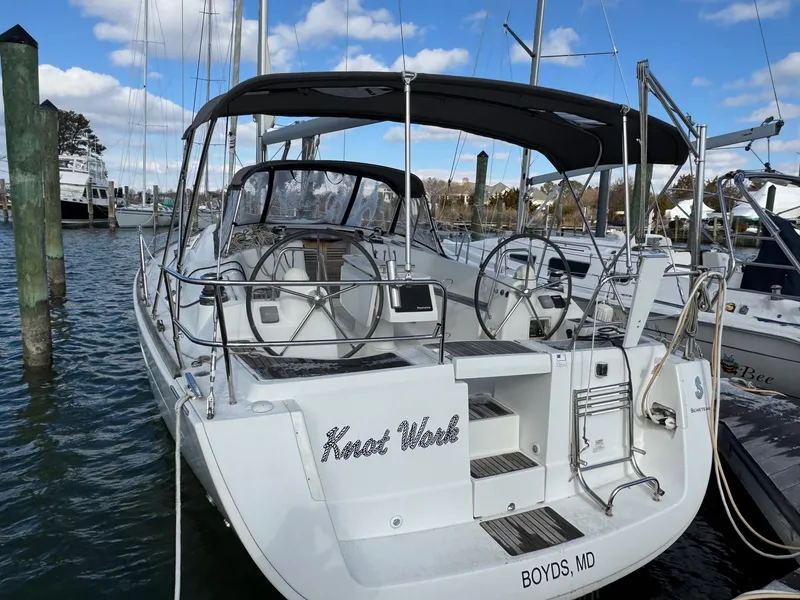 Slide: The Image of 2012 Beneteau 40 sailboat docked, featuring dual steering wheels and a spacious cockpit. - 7