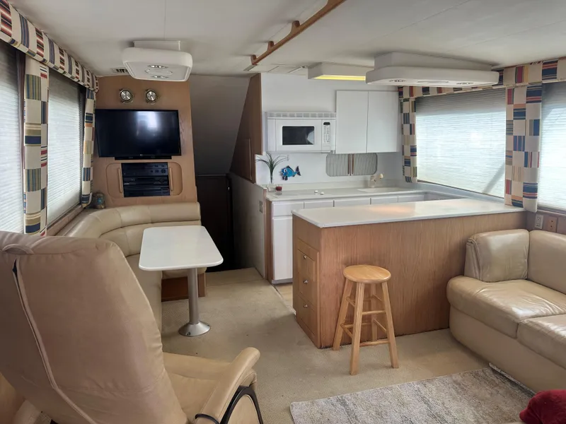 Slide: The Image of White kitchen interior on a 1996 Hatteras 50 Convertible yacht, featuring cabinets and appliances. - 11