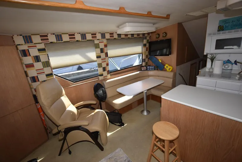 Slide: The Image of Interior of 1996 Hatteras 50 Convertible yacht with beige seating and patterned curtains. - 13
