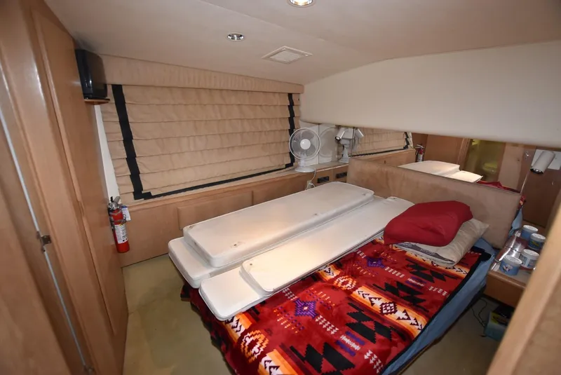 Slide: The Image of Bunk beds in a 1996 Hatteras 50 Convertible yacht cabin, featuring red and black bedding. - 16