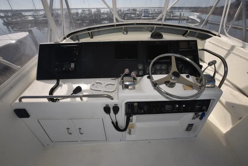 Slide: The Image of 1996 Hatteras 50 Convertible helm with steering wheel and control panel. - 32