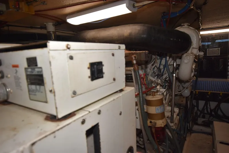 Slide: The Image of Engine room of a 1996 Hatteras 50 Convertible yacht, featuring complex machinery and equipment. - 36