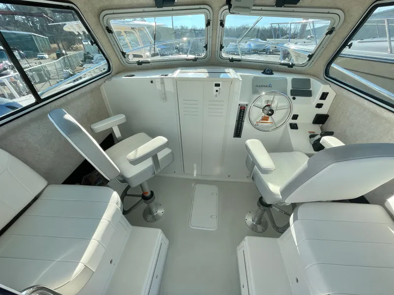 Slide: The Image of Interior of 2020 Parker 2520 XLD Sport Cabin boat with seating and steering wheel. - 8