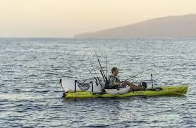 Slide: The Image of Person fishing on a 2022 Hobie Revolution 13 kayak in open water at sunset. - 4