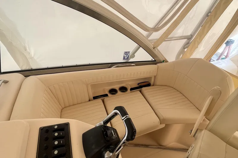 Slide: The Image of 2012 Grady-White Express 305 boat interior with beige seating and steering controls. - 10