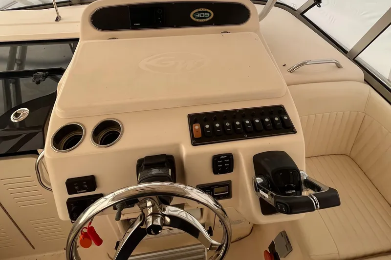 Slide: The Image of 2012 Grady-White Express 305 boat helm with steering wheel and control panel. - 8