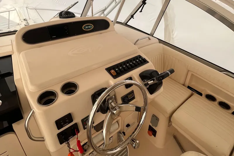 Slide: The Image of 2012 Grady-White Express 305 boat helm with steering wheel and control panel. - 9
