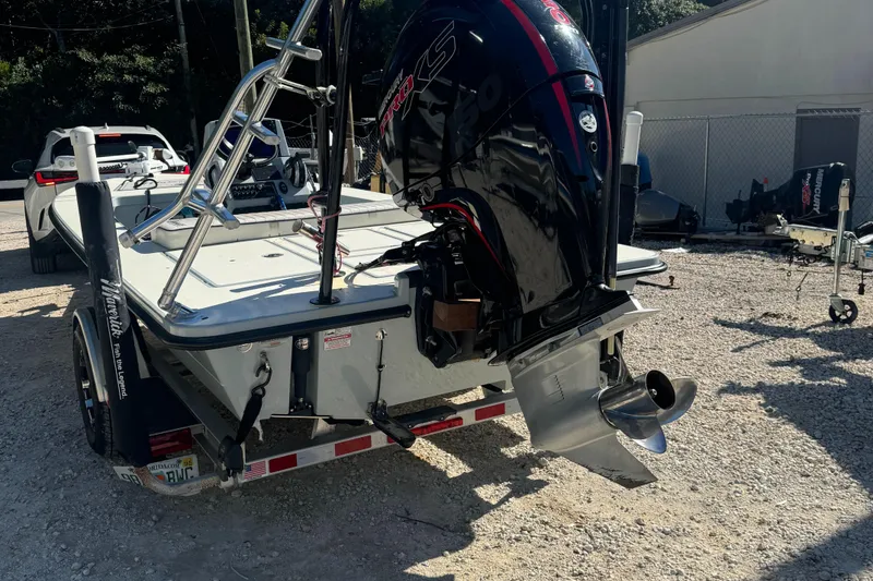 Slide: The Image of 2016 Maverick 18 HPX-V boat with outboard motor on trailer, parked outdoors. - 2