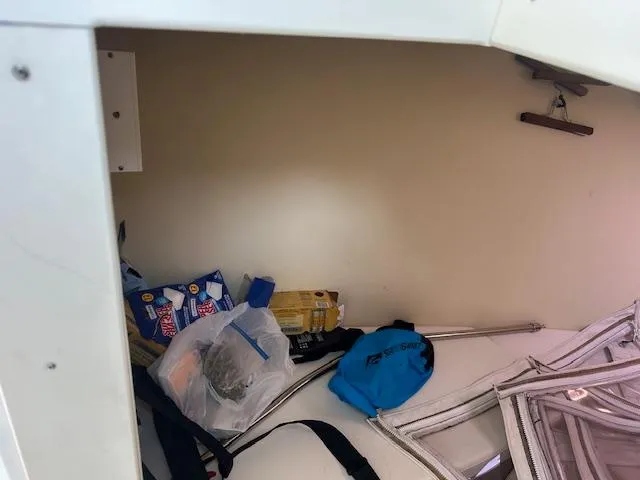 Slide: The Image of Storage area inside a 2011 Custom Carolina 26 boat with various items and supplies. - 12