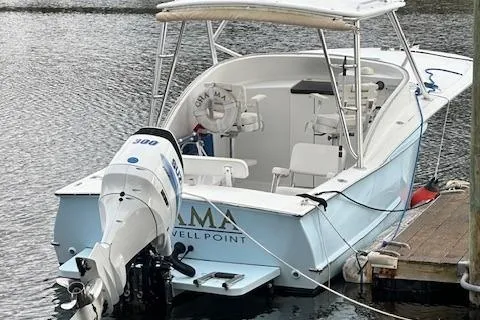 Slide: The Image of Custom Carolina 26 boat, 2011 model, docked with outboard motor, light blue hull. - 2