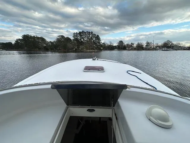 Slide: The Image of Custom Carolina 26 boat on calm water, 2011 model, under a cloudy sky. - 5