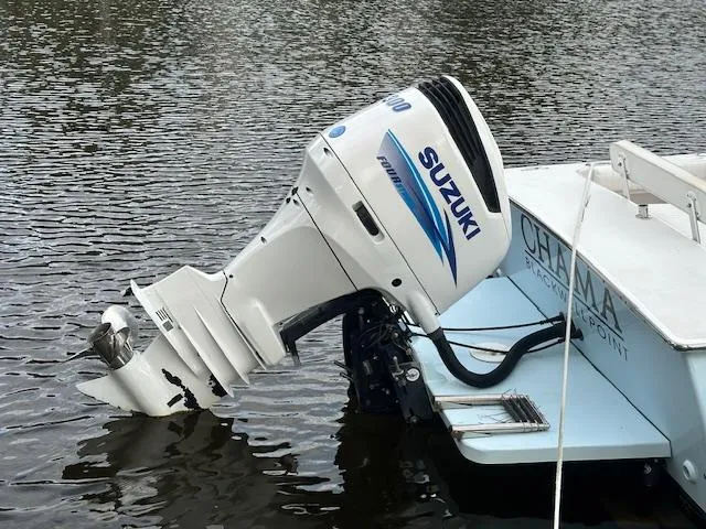 Slide: The Image of Outboard motor on 2011 Custom Carolina 26 boat, Suzuki engine, docked on calm water. - 7