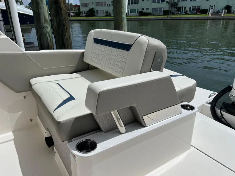 Slide: The Image of 2022 Tiara Yachts 34 LX boat seating area with elegant upholstery and cup holders. - 15