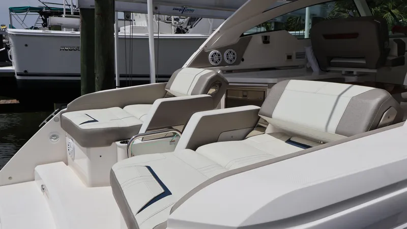 Slide: The Image of 2022 Tiara Yachts 34 LX interior seating, showcasing luxurious white and beige upholstery. - 16