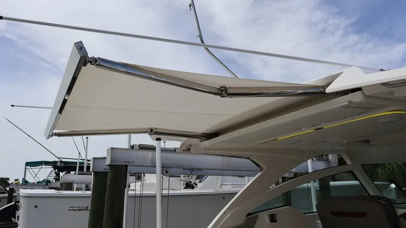 Slide: The Image of 2022 Tiara Yachts 34 LX with extended canopy at a marina. - 21