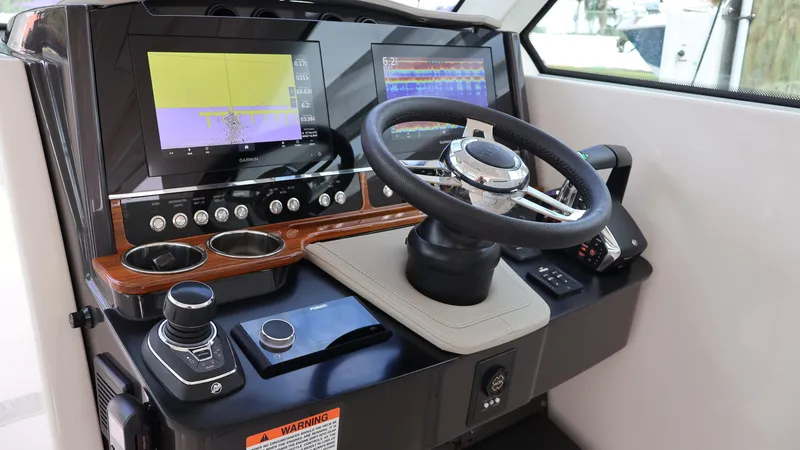 Slide: The Image of 2022 Tiara Yachts 34 LX helm with modern controls and dual navigation screens. - 35