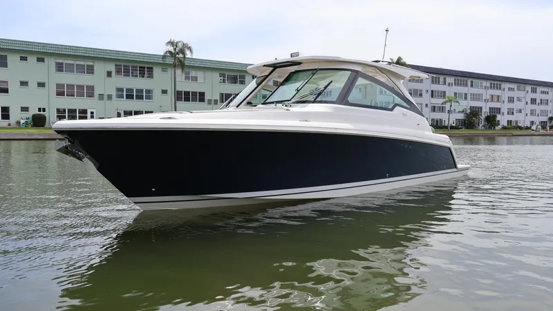 Slide: The Image of 2022 Tiara Yachts 34 LX on calm water near residential buildings. - 5