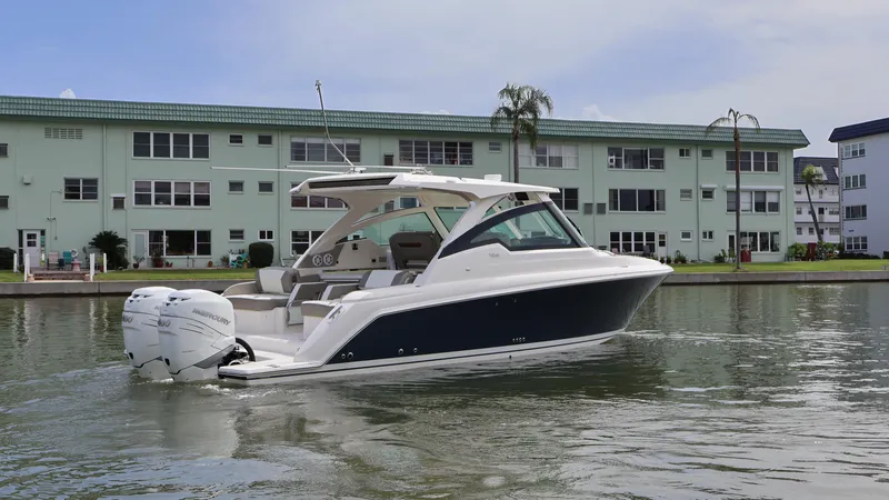 Slide: The Image of 2022 Tiara Yachts 34 LX boat on water near residential buildings. - 6