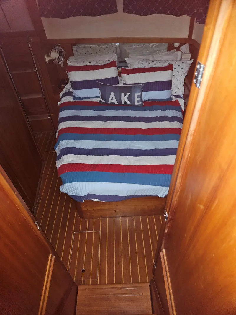 Slide: The Image of Cozy bedroom in 1998 Sabre 36 Fast Trawler with striped bedding and "Lake" pillow. - 14