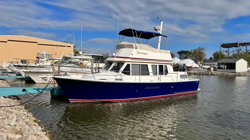 Slide: The Image of 1998 Sabre 36 Fast Trawler docked at a marina under a partly cloudy sky. - 5