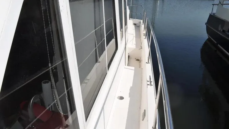 Slide: The Image of 1998 Sabre 36 Fast Trawler side deck view with railing and windows. - 9