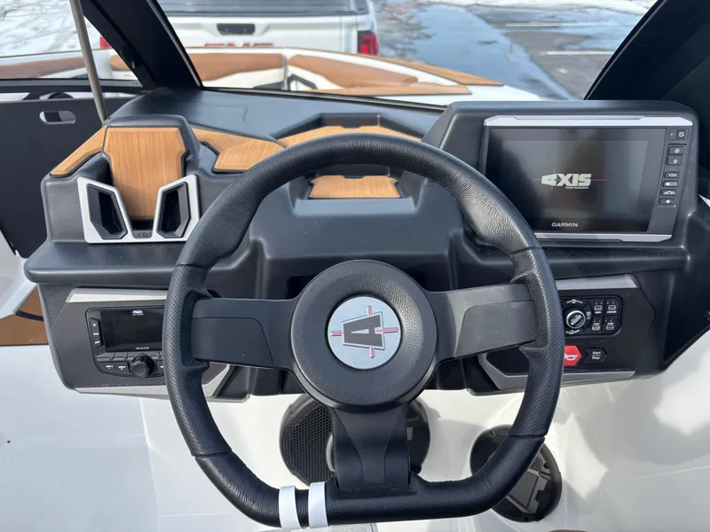 Slide: The Image of Steering wheel and dashboard of 2025 Axis T220 boat, featuring modern controls and display. - 2