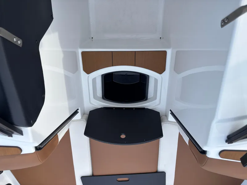 Slide: The Image of 2025 Axis T220 boat interior with brown and black seating and storage compartments. - 3