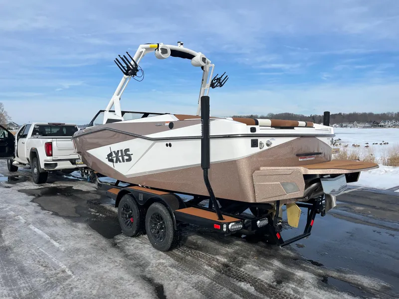 Slide: The Image of 2025 Axis T220 boat on trailer, parked on snowy road near lake. - 6
