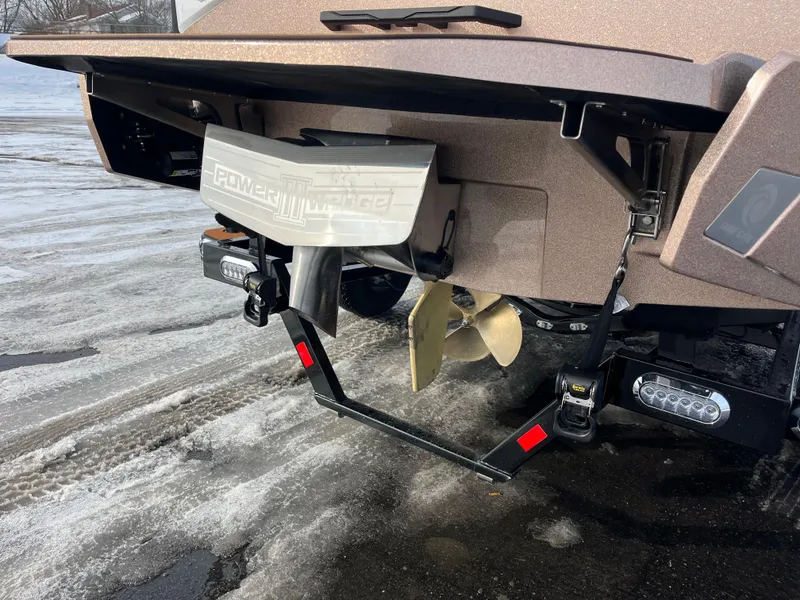 Slide: The Image of 2025 Axis T220 boat stern with propeller and Power Wedge, on wet pavement. - 7