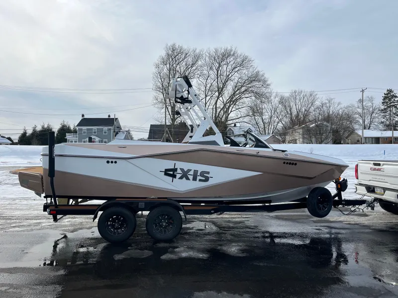 Slide: The Image of 2025 Axis T220 boat on trailer, parked outdoors in winter setting. - 9
