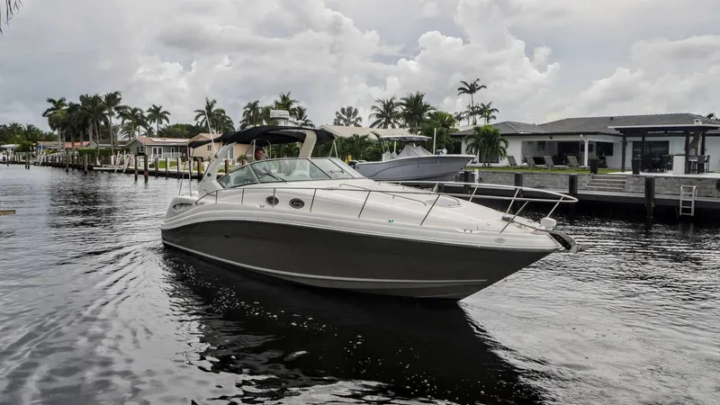 Slide: The Image of 2007 Sea Ray 340 Sundancer boat cruising on a calm waterway, surrounded by palm trees. - 1