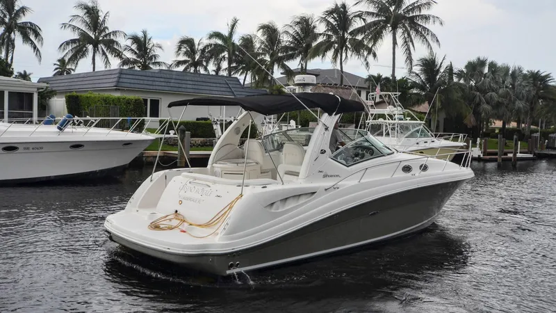 Slide: The Image of 2007 Sea Ray 340 Sundancer yacht docked near palm trees and waterfront homes. - 2
