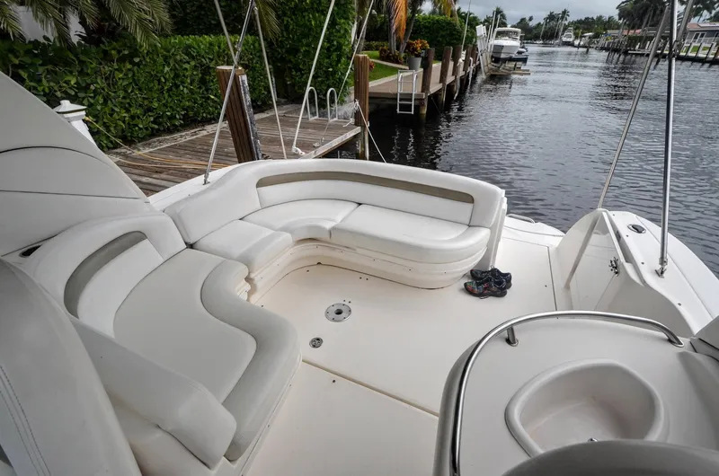 Slide: The Image of 2007 Sea Ray 340 Sundancer boat with white seating, docked by a lush waterfront. - 27
