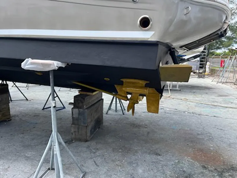 Slide: The Image of 2007 Sea Ray 340 Sundancer boat hull on dry dock, showing propeller and rudder. - 40