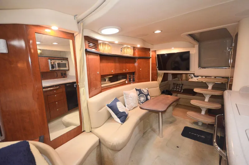 Slide: The Image of 2007 Sea Ray 340 Sundancer interior with plush seating, wooden cabinetry, and modern amenities. - 6