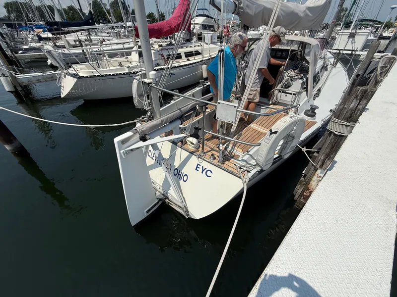 Slide: The Image of 1986 Abbott 36 sailboat docked, with two people on deck, in a marina setting. - 13