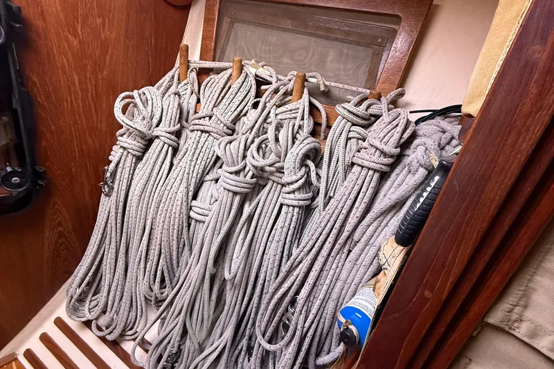 Slide: The Image of Coiled ropes neatly stored on a 1986 Abbott 36 sailboat, showcasing organized sailing equipment. - 21