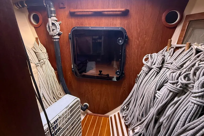 Slide: The Image of Interior of 1986 Abbott 36 sailboat with coiled ropes and wooden paneling. - 22