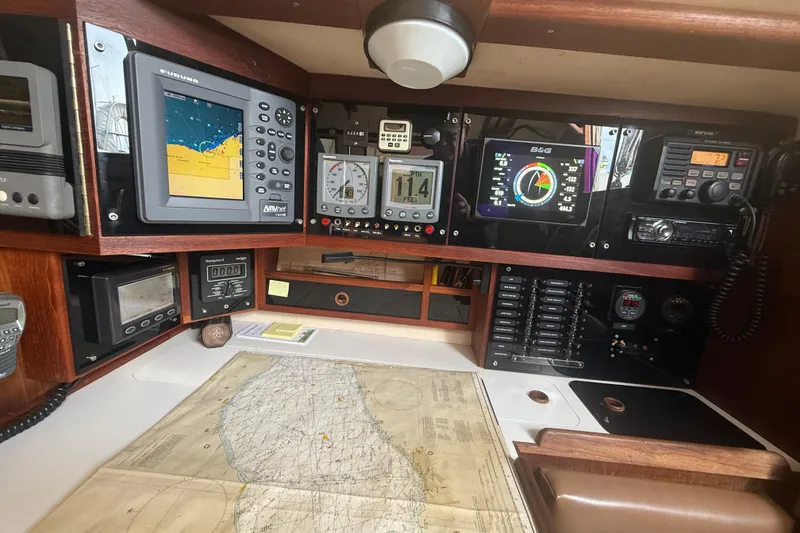 Slide: The Image of Navigation equipment and map inside a 1986 Abbott 36 sailboat cabin. - 23